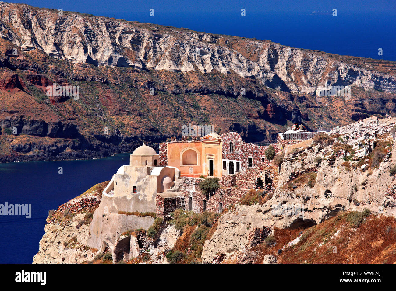 La chiesa di San Nicola a destra sopra la caldera sul bordo del villaggio di Oia, Cicladi Mar Egeo. In background, Thirassia; isola. Foto Stock
