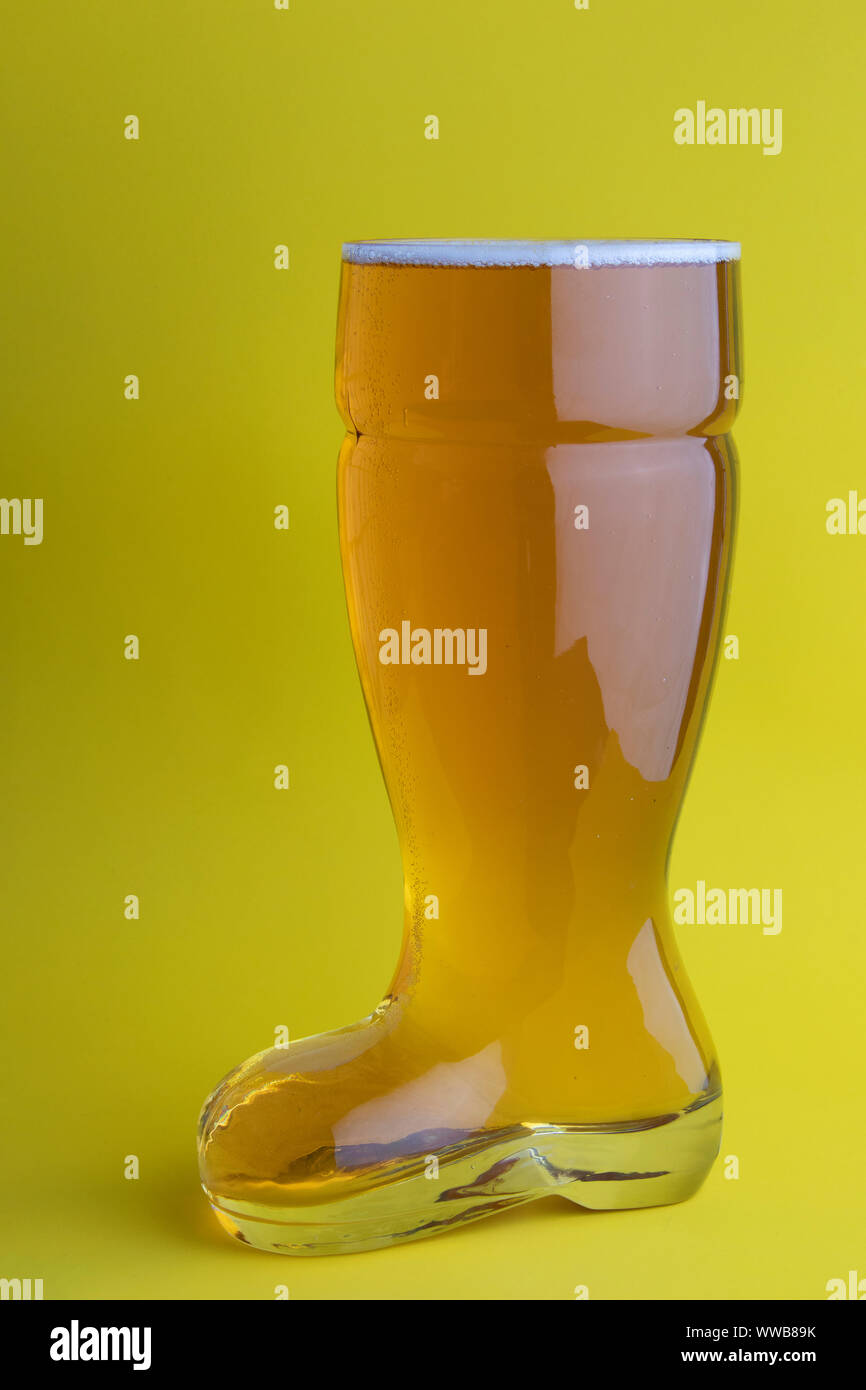 La birra nel bagagliaio di un bicchiere di birra in sfondo giallo Foto Stock