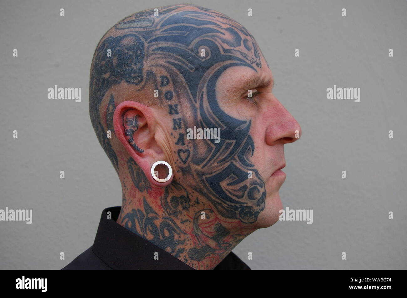 La guardia di sicurezza con arte del corpo sul suo volto. Foto Stock