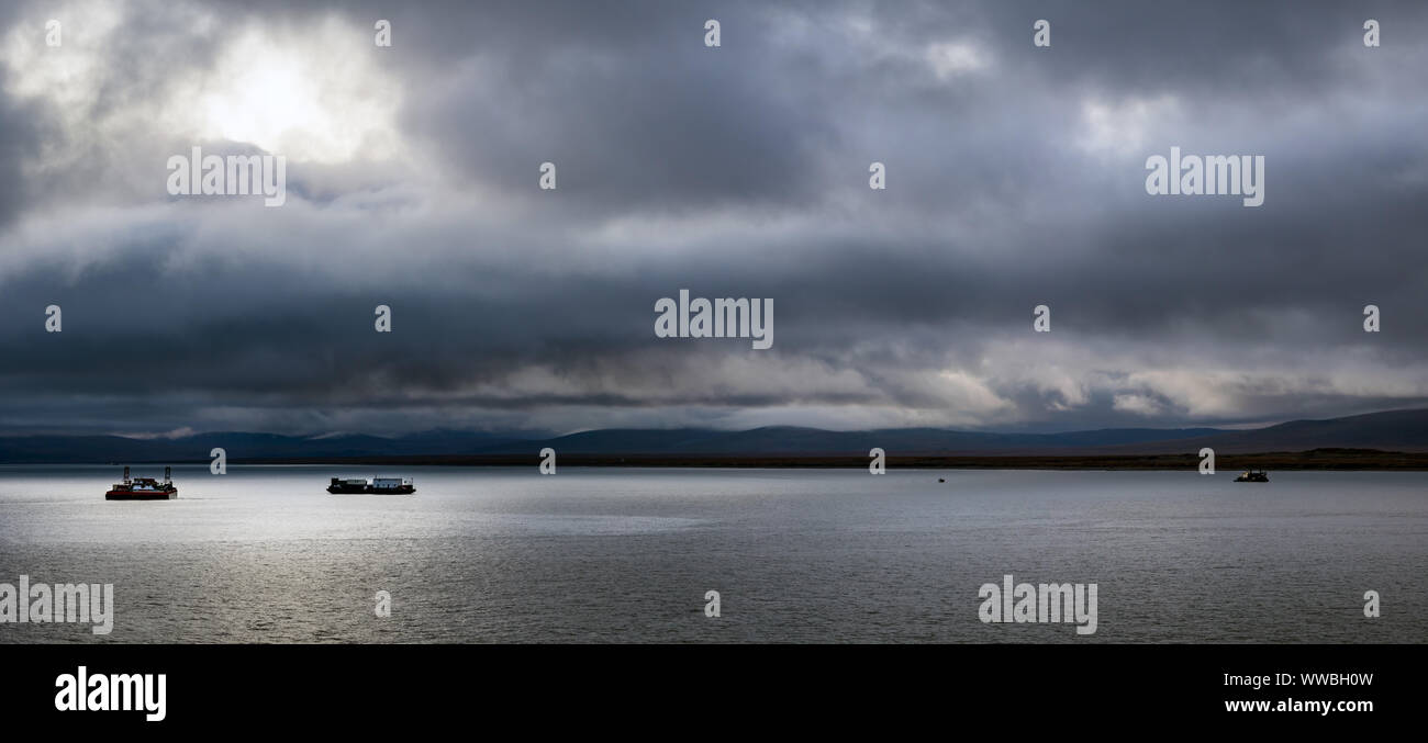Panorama di tre navi per il mare di Bering e St Lawrence isola sullo sfondo al tramonto in un giorno di tempesta, Alaska. Foto Stock