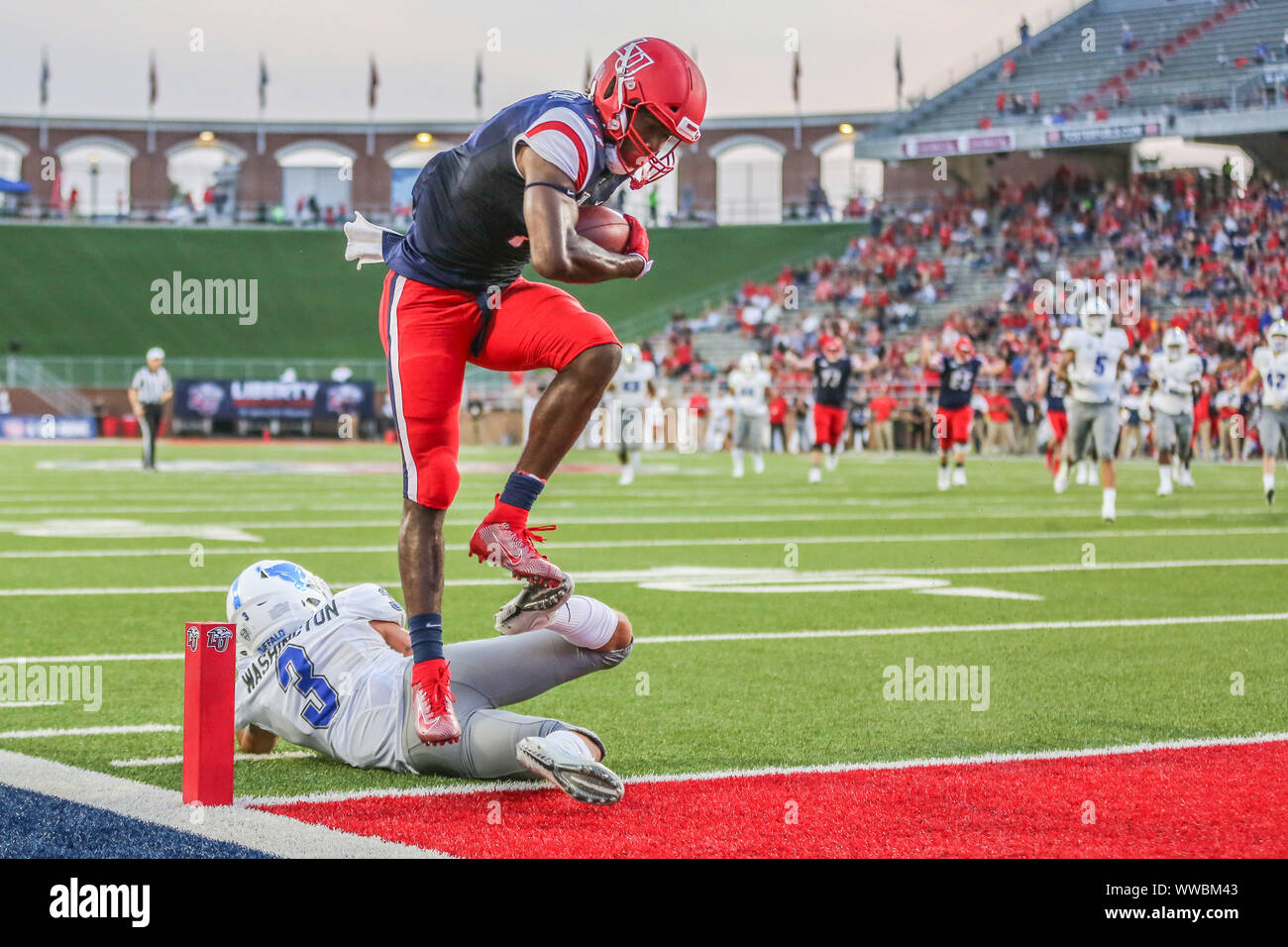 Lynchburg, VA, Stati Uniti d'America. Xiv Sep, 2019. Liberty fiamme wide receiver Antonio Gandy-Golden (11) ostacoli Buffalo tori cornerback Aapri Washington (3) al cliente un secondo trimestre touchdown durante il NCAA Football azione tra la bufala tori e il Liberty fiamme a Williams Stadium di Lynchburg, VA. Jonathan Huff/CSM/Alamy Live News Foto Stock