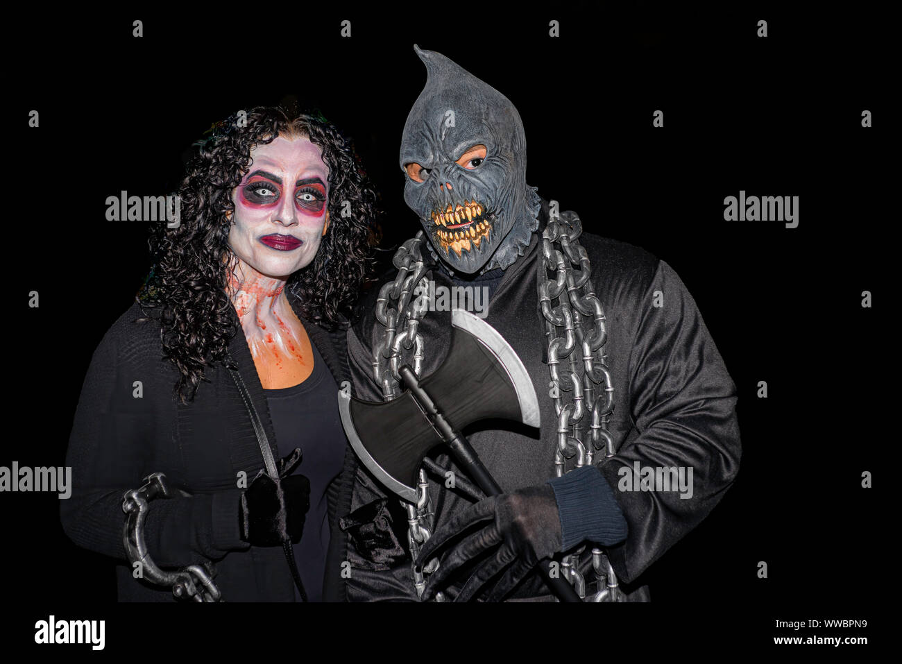Salem Massachusetts USA 10/31/2015. L uomo e la donna viso trucco e maschera su una oscura notte di Halloween. Solo uso editoriale Foto Stock