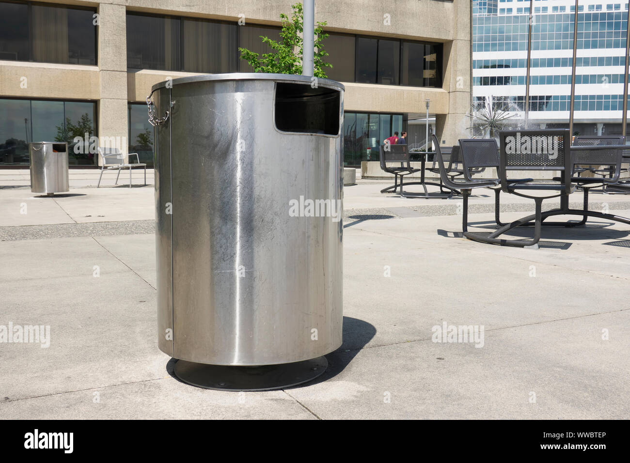Una spazzatura di acciaio inossidabile può su un patio di cemento in uno spazio pubblico a Vancouver, B.C., Canada. Foto Stock