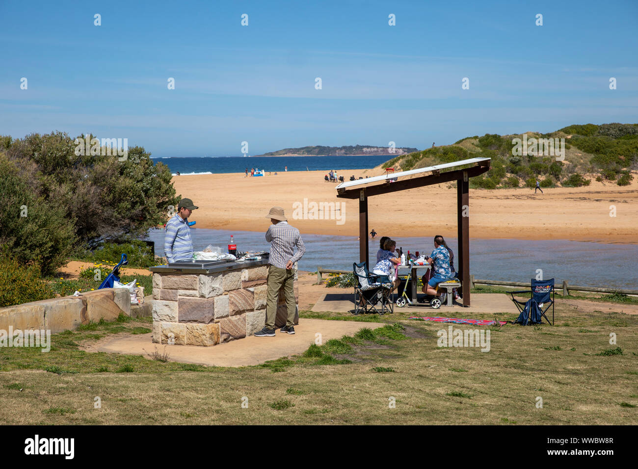 Due uomini australiani che cucinano su un barbecue sulla spiaggia a Narrabeen sulle spiagge settentrionali di Sydney, New South Wales, Australia Foto Stock