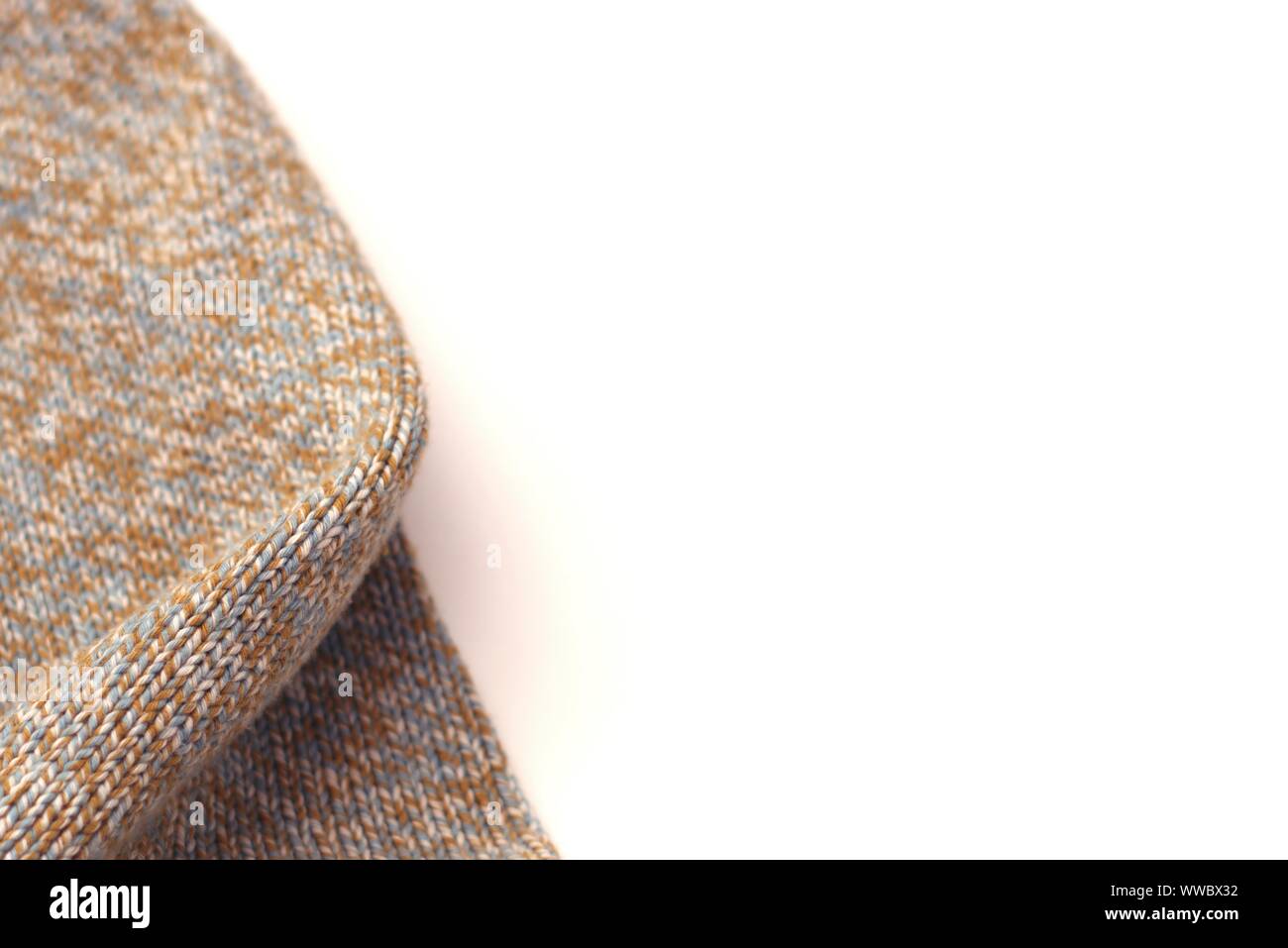 Chiazzato beige maglia maglione di lana su sfondo bianco. Texture Detail close up. Lo spazio negativo. Foto Stock