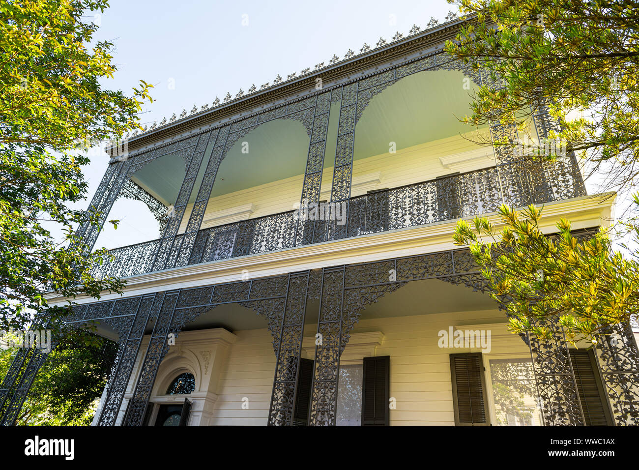 New Orleans, Stati Uniti d'America - 23 Aprile 2018: la vecchia strada giardino storico distretto in Louisiana città con real estate storico giallo nero house mansion con cas Foto Stock