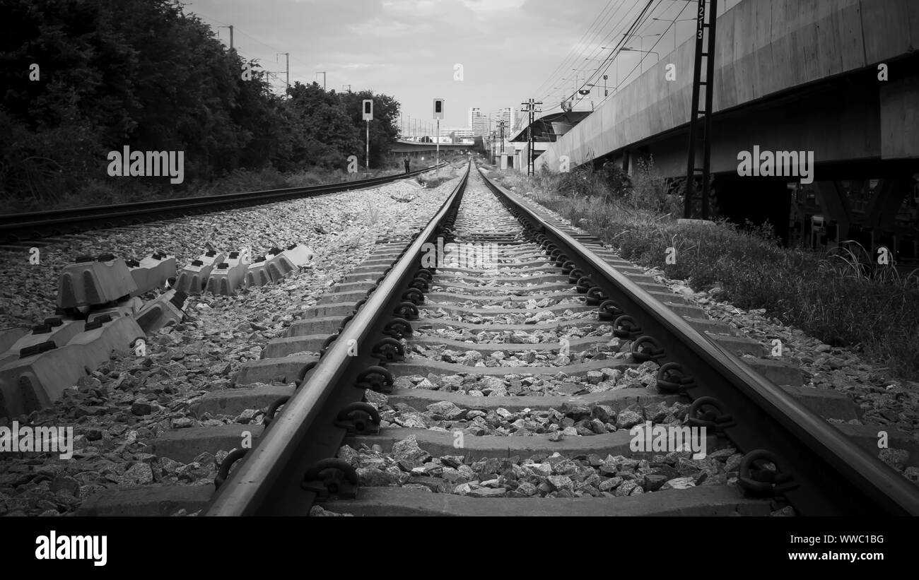Stazione ferroviaria vuoto con nessun treno e persone, messa a fuoco selettiva e in stile vintage. Ferrovia e bellissimo cielo al tramonto in estate. Rurali paesaggio industriale Foto Stock