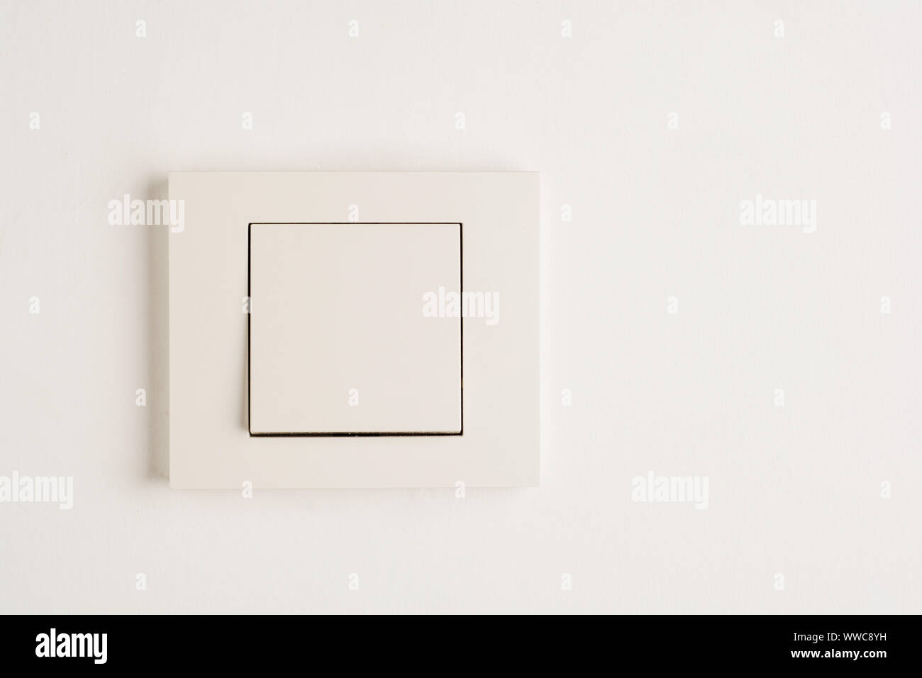 Interruttore elettrico con spazio per il testo sulla parete bianca. Foto Stock