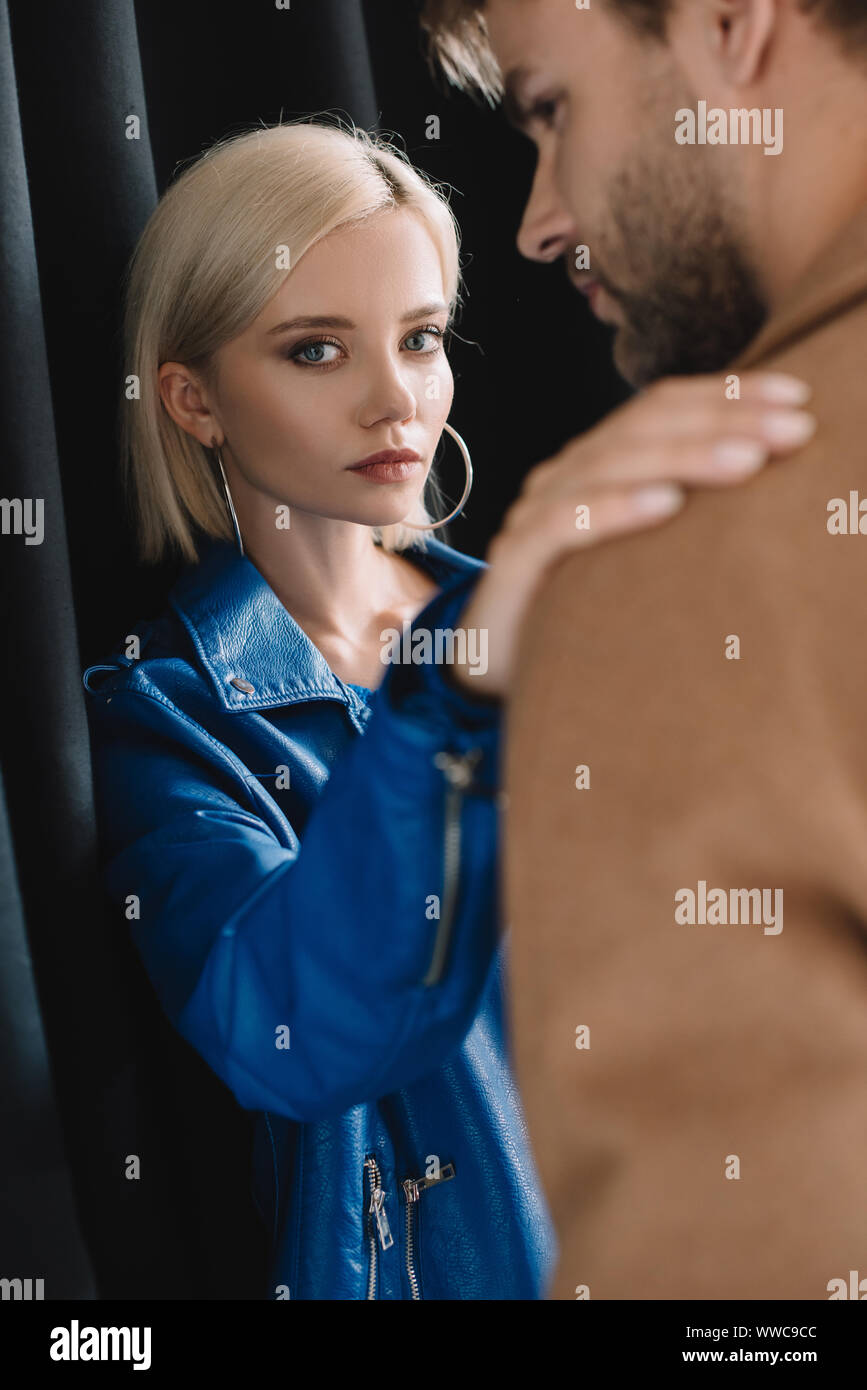 Elegante giovane donna e uomo in autunno i vestiti vicino alla tenda nera Foto Stock