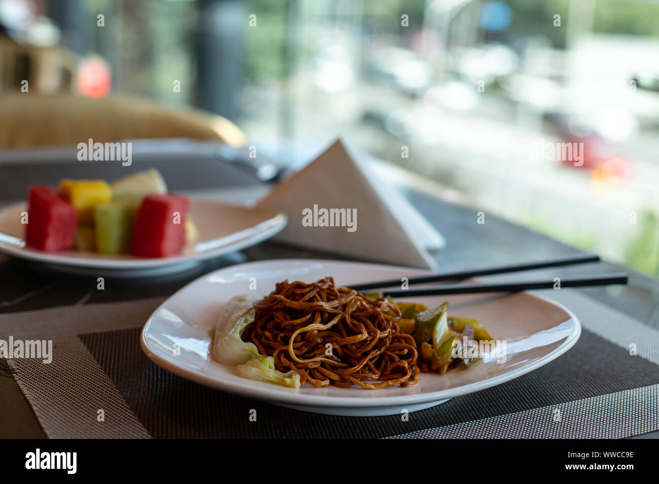 Cinese noodles fritti e bastoncini. Piatto di lato di sedano e le carote. Cavolo cinese. Marrone spaghetti cinesi con verdure. Foto Stock