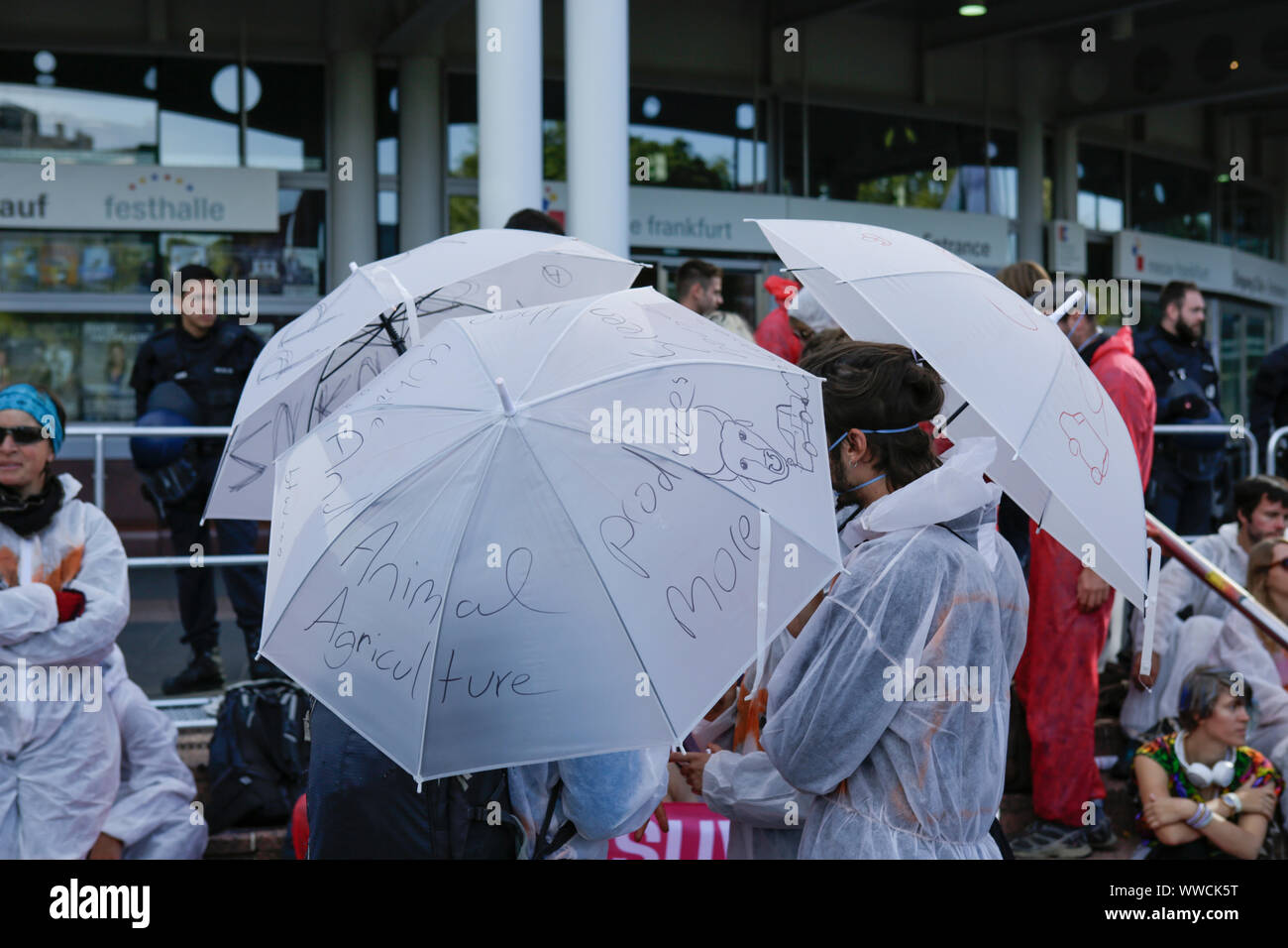 Francoforte, Germania. Il 15 settembre 2019. I manifestanti portano ombrelloni bianchi con slogan su di esso. Diverse centinaia di attivisti hanno protestato fuori del 2019 Internationale Automobil-Ausstellung (IAA) contro le automobili e per un cambiamento nelle politiche del traffico. Hanno bloccato diversi ingressi alla mostra. Foto Stock