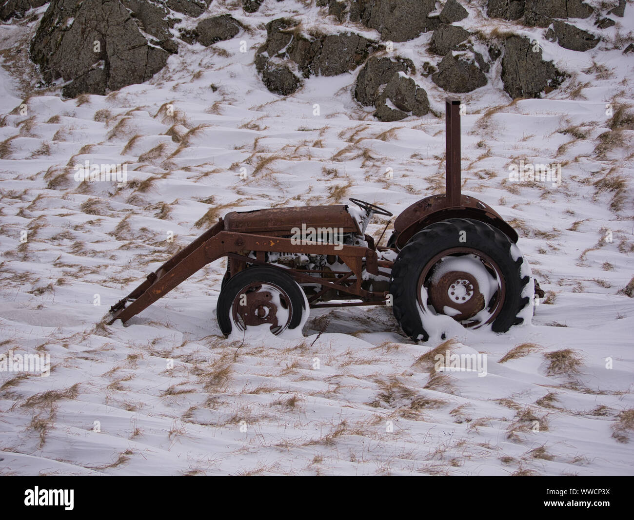 Un vecchio arrugginito trattore su un prato nevoso in Islanda Foto Stock