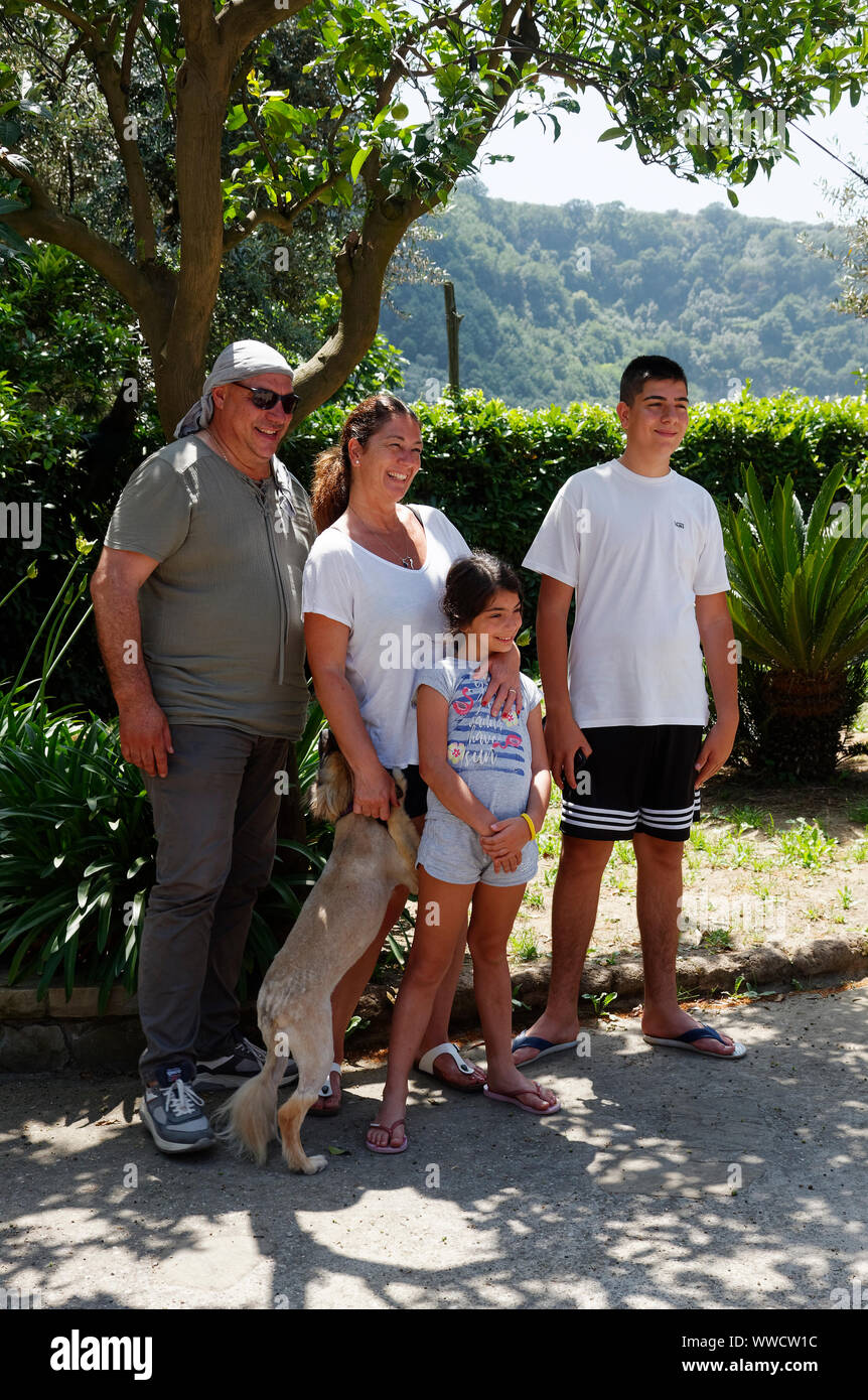 La famiglia felice, padre, madre, figlio, figlia, sorridente, cane, casual ritratto a piena lunghezza; verticale; signor Foto Stock