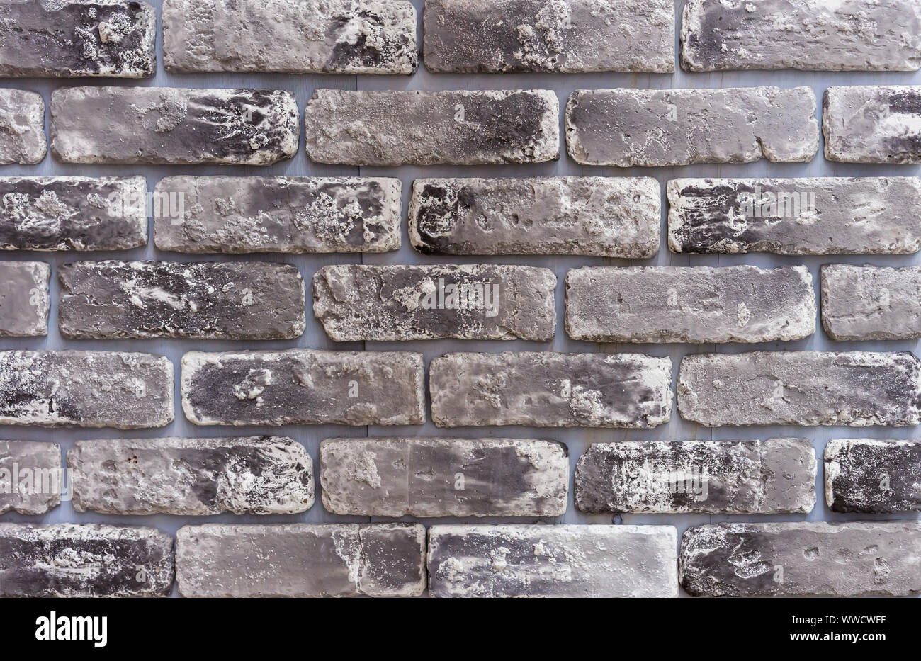 Texture di mattoni grigi con accenti di colore nero. Foto Stock