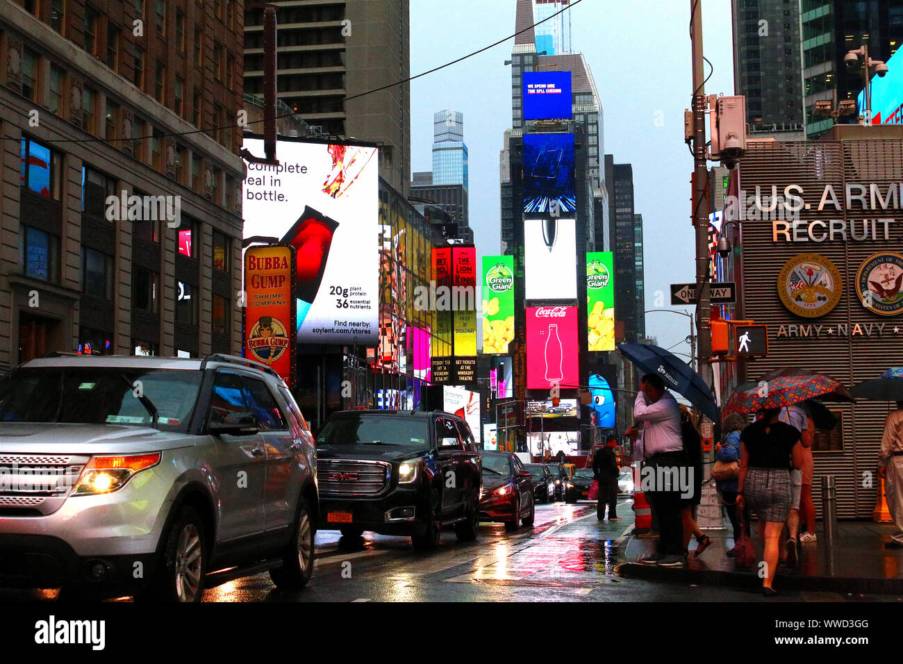 Il traffico di pedoni, ciclisti e automobili trudges attraverso Times Square in un pomeriggio piovoso. Manhattan su luglio 31st, 2019 a New York, Stati Uniti d'America. (Foto di Foto Stock