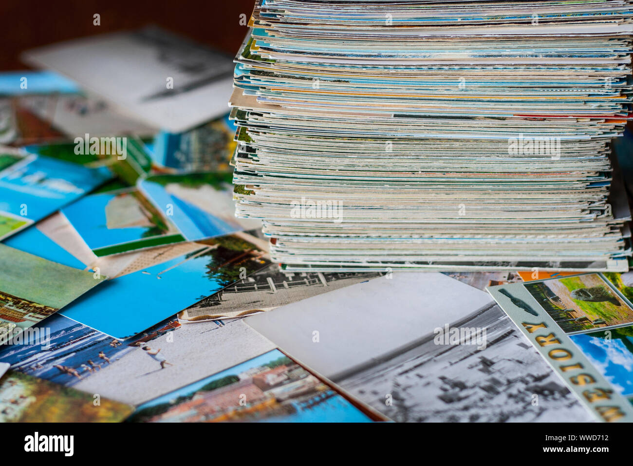Pila di poche centinaia di cartoline vecchie raccolta su altre cartoline sparsi intorno al tavolo Foto Stock
