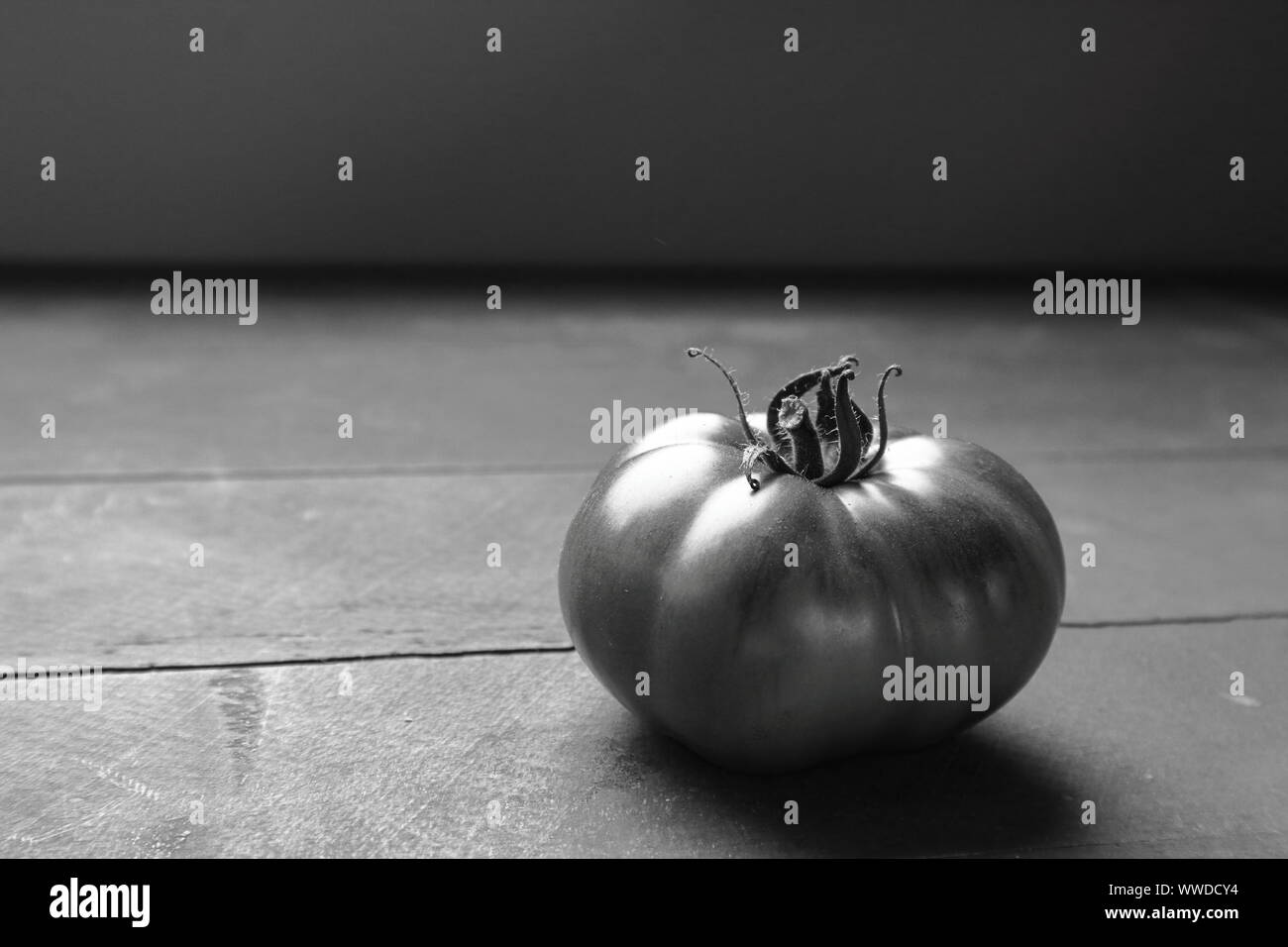 In bianco e nero di pomodori del patrimonio su una tavola in legno rustico Foto Stock