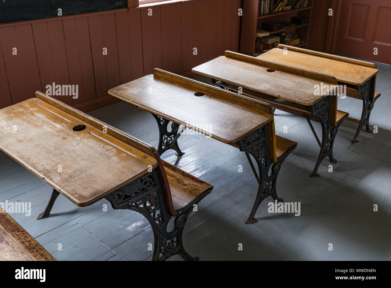 Scrivanie allineate in una vecchia scuola di camera house Foto Stock
