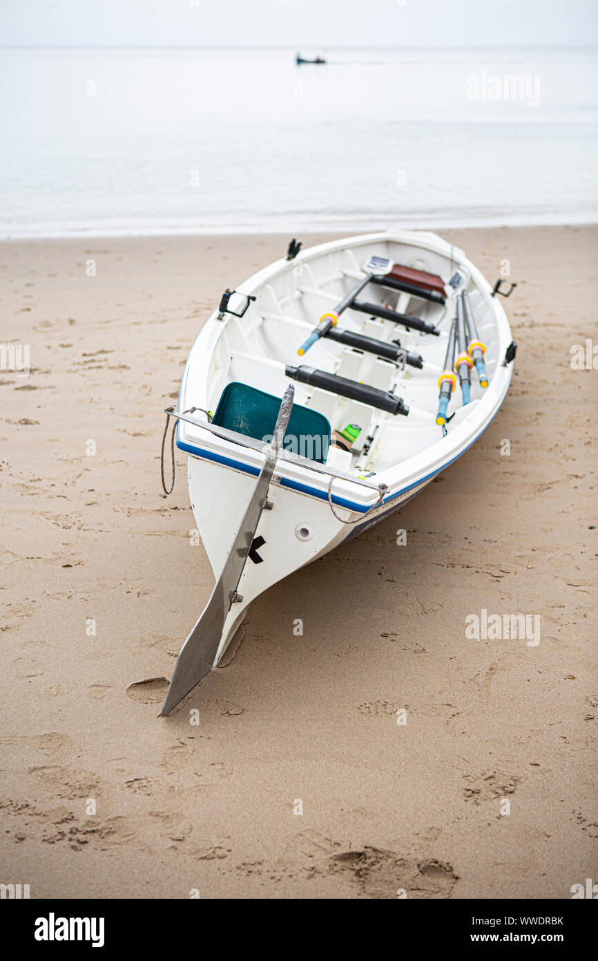 Barca a remi sulla spiaggia in Tenby Galles Foto Stock