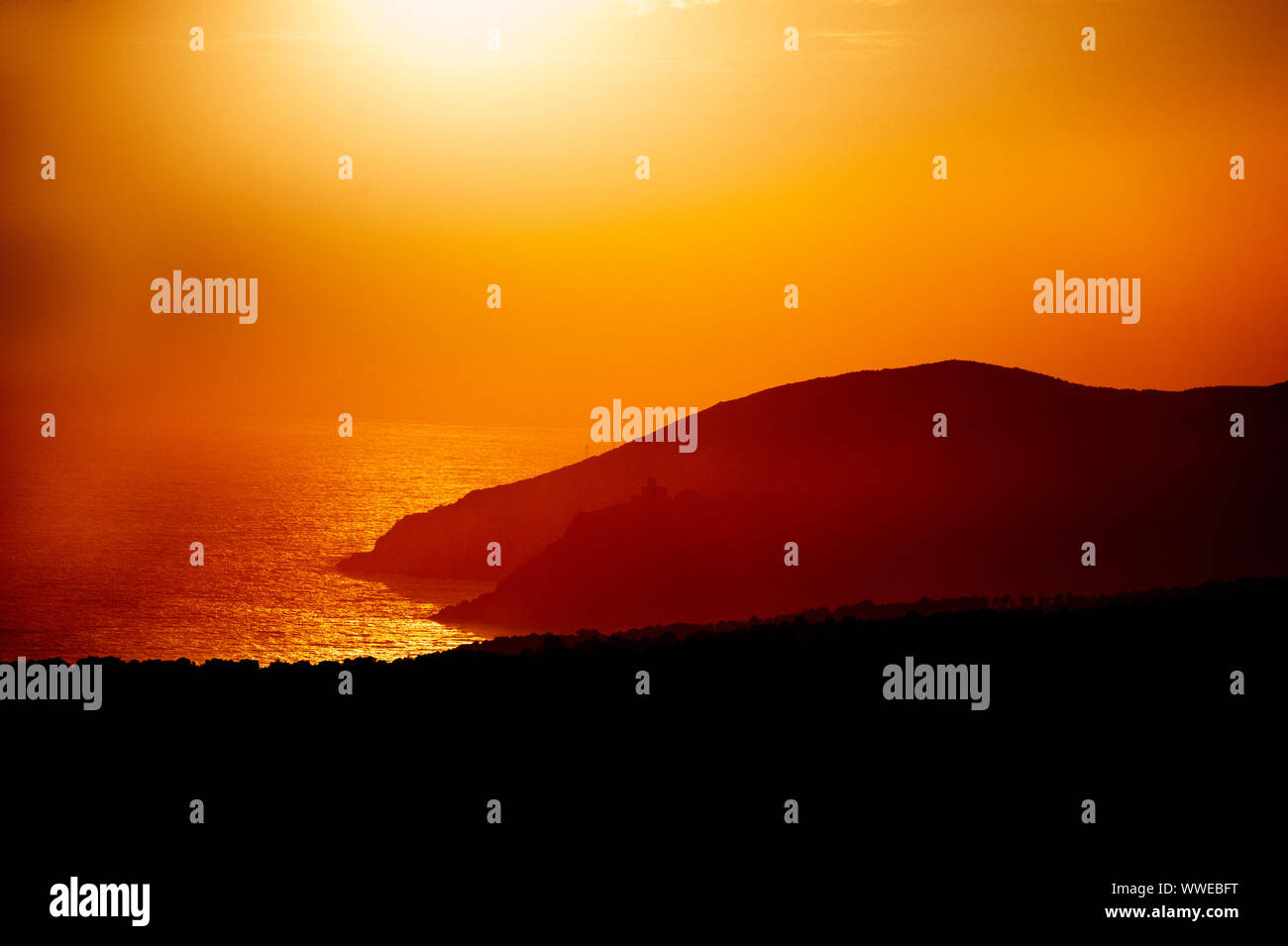 Mar Ligure. Rosso tramonto. La luce diretta del sole nel mare blu alla sera. Foto Stock