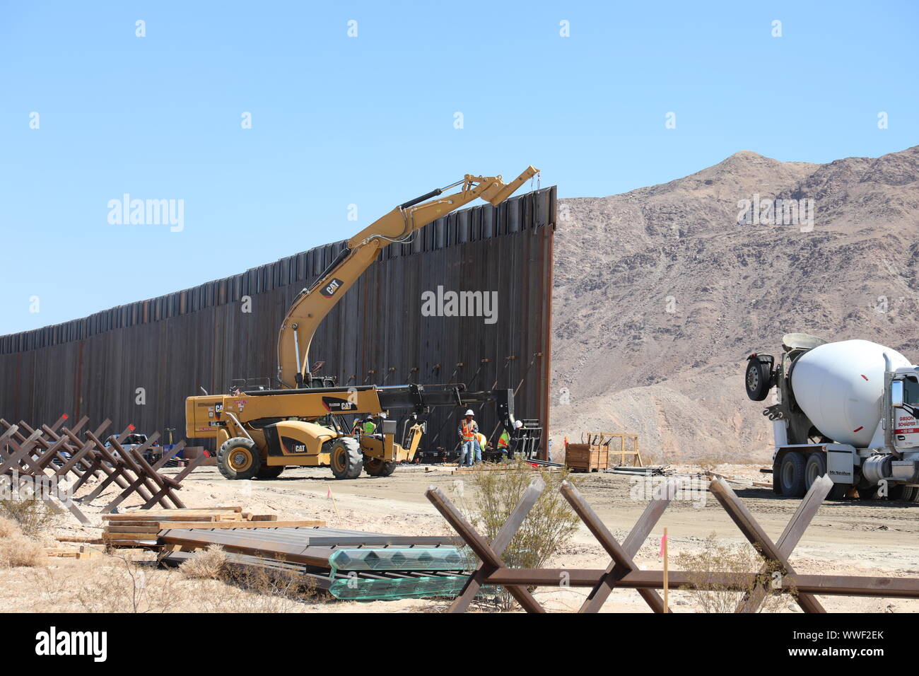Un U.S. Esercito di ingegneri contraente utilizzi un escavatore per abbassare un acciaio bollard pannello di barriera in posizione nei pressi di El Centro in California, Sett. 12, 2019. Questi progetti sono in corso di esecuzione da USACE, come diretto attraverso gli Stati Uniti Esercito dal Segretario della Difesa, in risposta al Dipartimento di Sicurezza della richiesta di assistenza per proteggere gli Stati Uniti frontiera meridionale bloccando i trafficanti di droga nei corridoi attraverso la costruzione di strade e di recinti, e l'installazione dei dispositivi di illuminazione sotto il titolo 10, Sezione 284 DEGLI STATI UNITI Codice. E DoD USACE sono esecuzione di questi progetti di sostegno Foto Stock