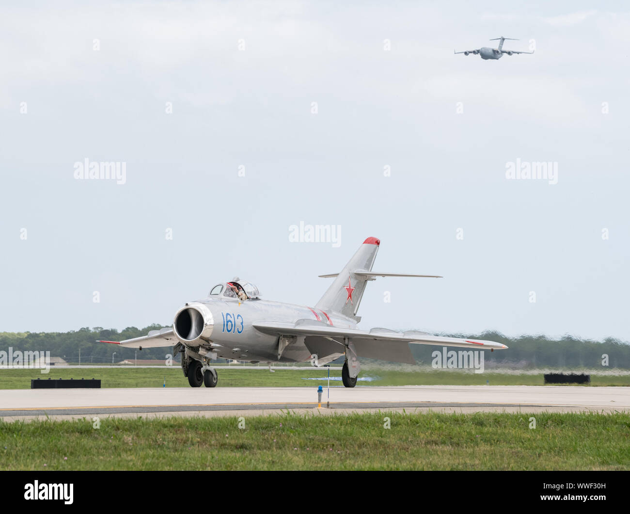 Un MiG-17 taxi come una C-17 Globemaster III si presenta per un passaggio basso durante il 2019 Thunder oltre Dover Air Show sett. 14, 2019, alla Dover Air Force Base, Del. open house ha montrato un spettro di aria americana potenza dalla II guerra mondiale a oggi. (U.S. Air Force Foto di Roland Balik) Foto Stock