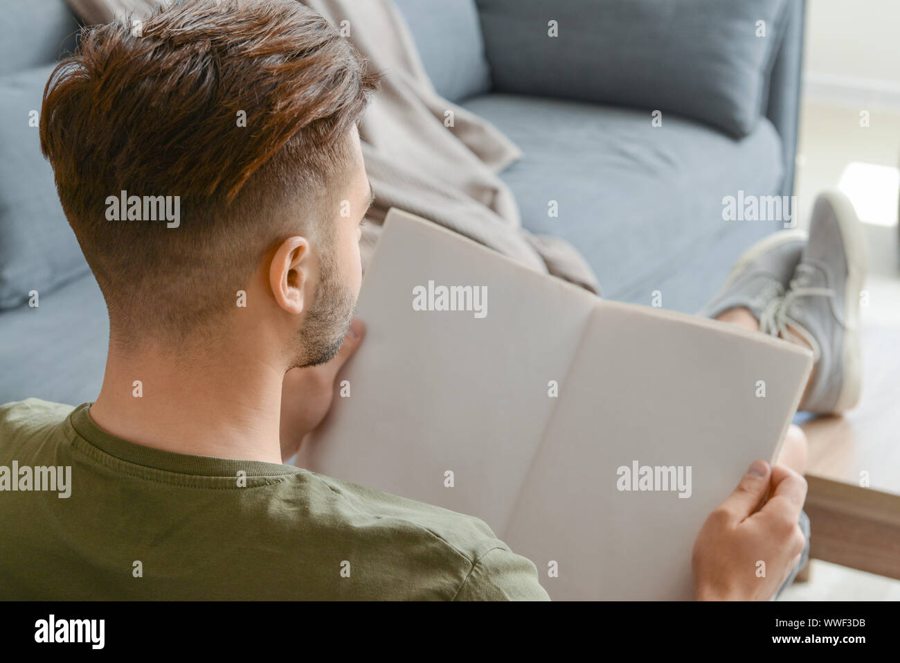 Uomo bello quotidiano di lettura a casa Foto Stock