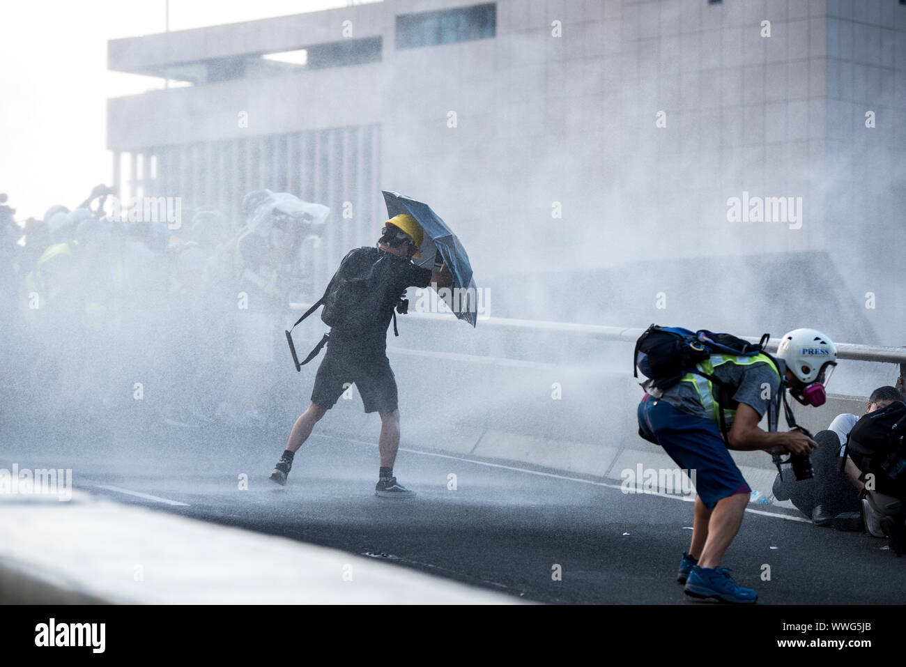 Hong Kong. Xv Sep, 2019. Un manifestante tentativi di deviare il liquido sparato da una polizia cannone ad acqua durante la dimostrazione.Migliaia di manifestanti hanno marciato per le strade del XV Settimana continuo di disordini. Mentre la dimostrazione ha iniziato pacificamente, manifestanti più tardi di fronte contro la polizia di fronte agli uffici del governo. I manifestanti hanno gettato mattoni e bombe a benzina mentre la polizia ha cercato di mantenere i dimostranti al bay da sparo decine di gas lacrimogeni turni e contundenti. Sommossa polizia eventualmente distribuito sui veicoli equipaggiati con acqua di cannoni e condotto una completa operazione di dispersione. Cred Foto Stock