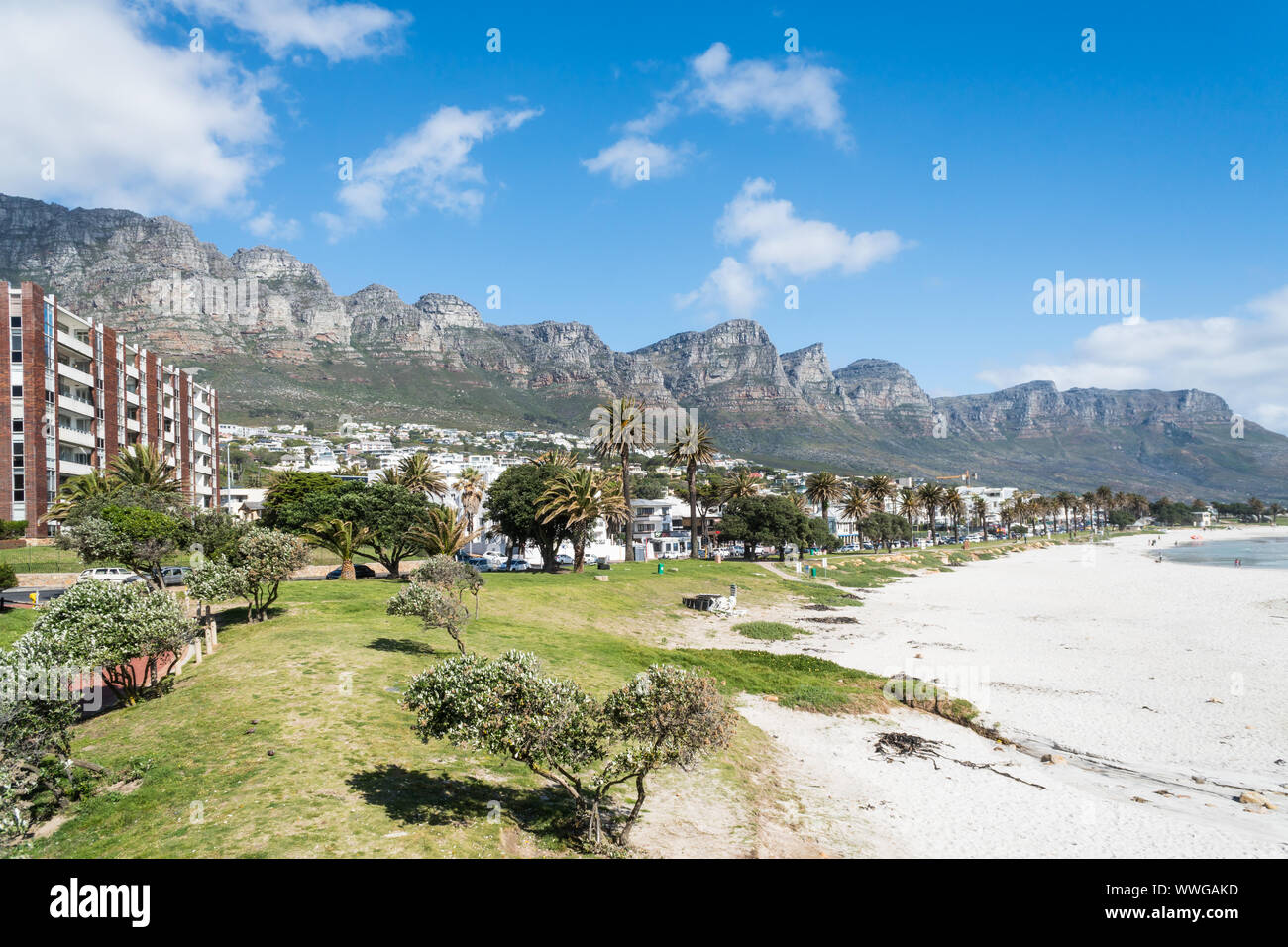 Camps Bay di sabbia bianca spiaggia bandiera blu di Città del Capo in Sud Africa vista panoramica sull'elegante sobborgo con dodici apostolo montagne sullo sfondo Foto Stock