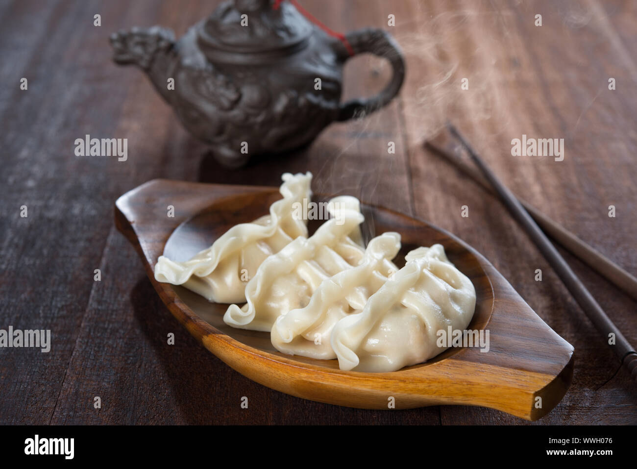 Gnocchi freschi con vapore caldo sulla piastra di legno. Popolare Cinese gourmet sul vecchio rustico in legno vintage background. Foto Stock