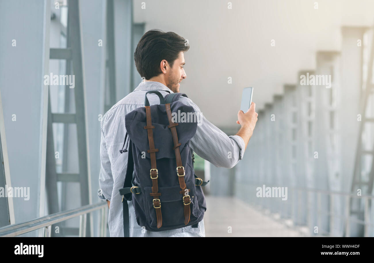 Tourist utilizzando il suo telefono cellulare in aeroporto, il collegamento al roaming Foto Stock