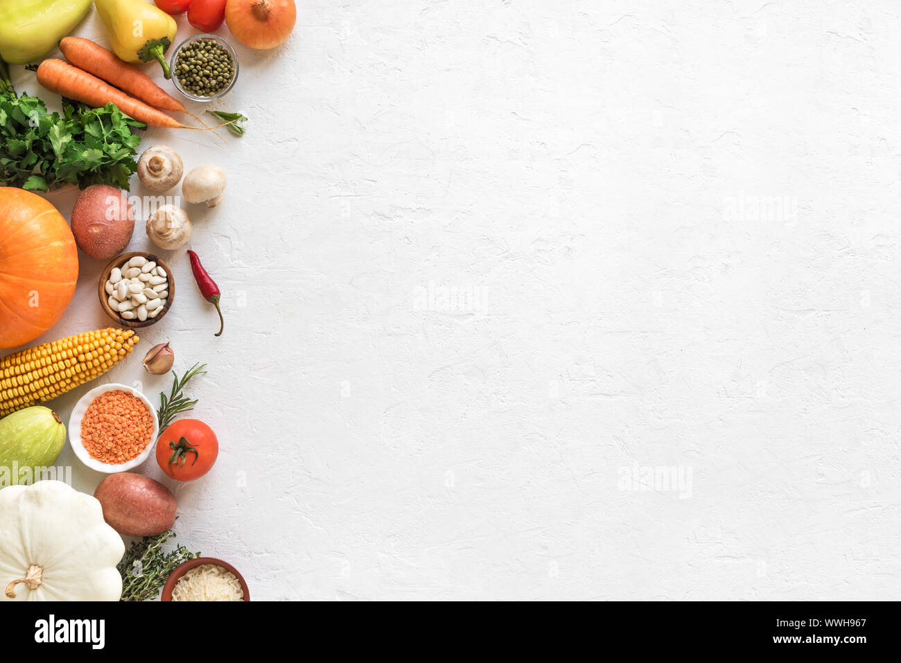 La cucina vegetariana sfondo stagionale con verdure biologiche e grani sul bianco, vista dall'alto, banner. Ingredienti per vegetariano vegano zuppe stagionali Foto Stock