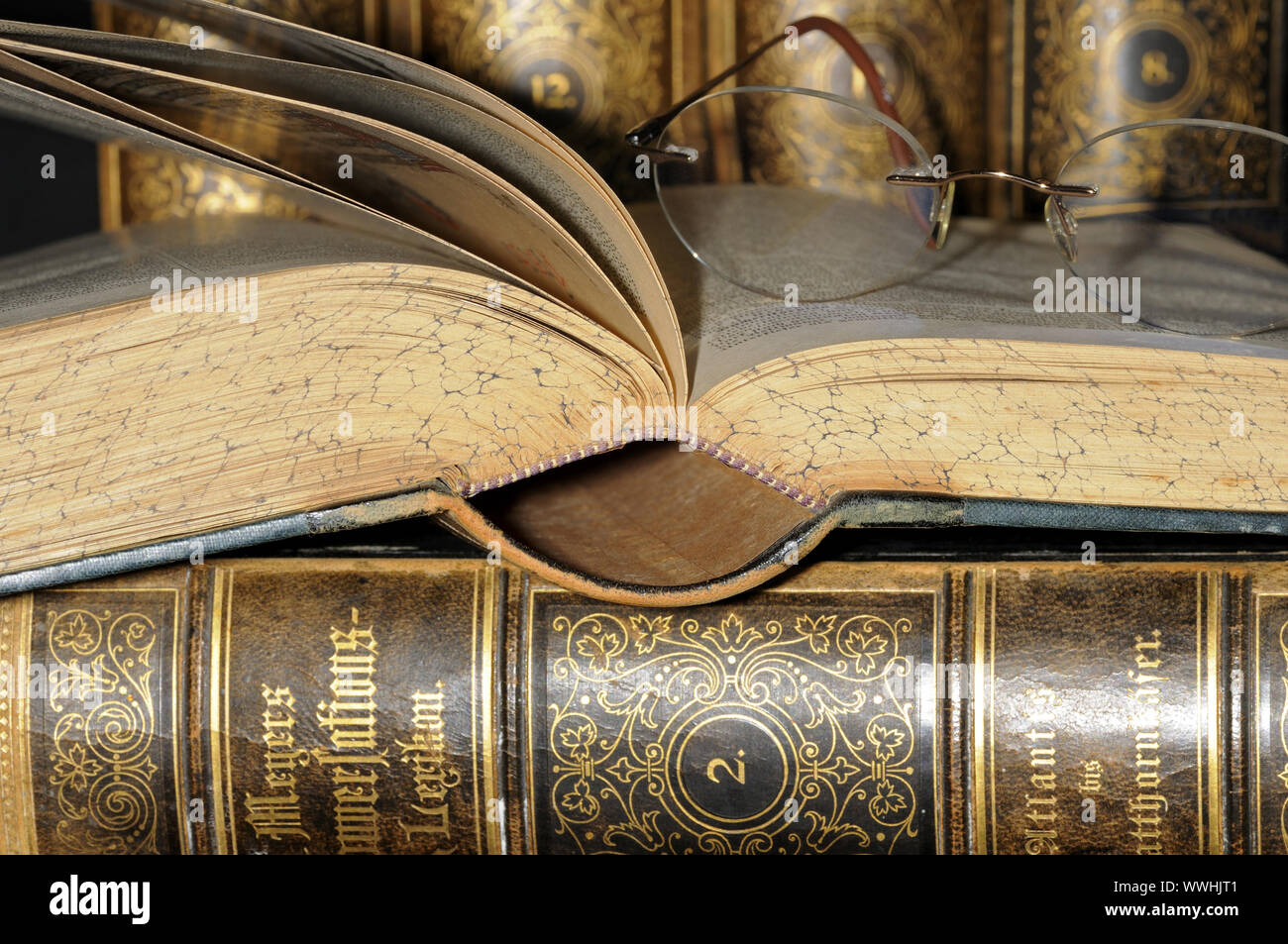 Gli occhiali da lettura e vecchie enciclopedie Foto Stock