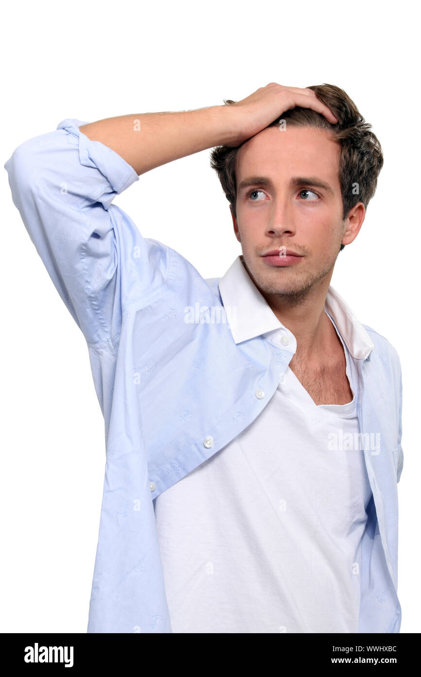 Giovane uomo che corre la sua mano attraverso i suoi capelli Foto Stock