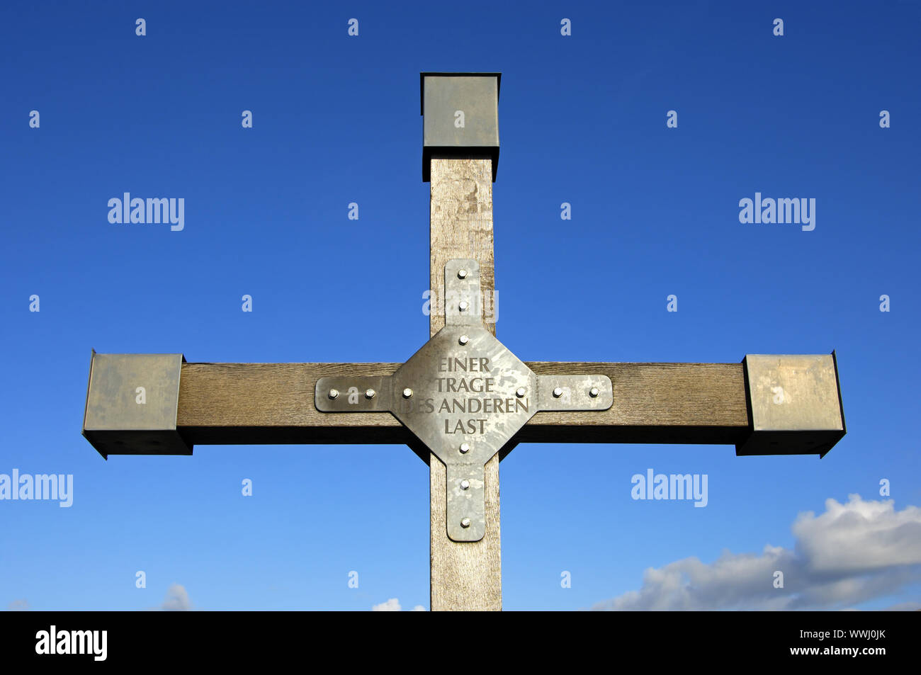Croce sull'alta foresta con il passaggio della Bibbia uno porta l'altro onere Foto Stock
