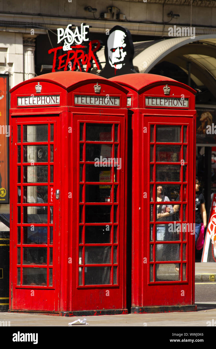 Tradizionale in rosso cabine telefoniche con il George corona nel centro cittadino di Londra Foto Stock
