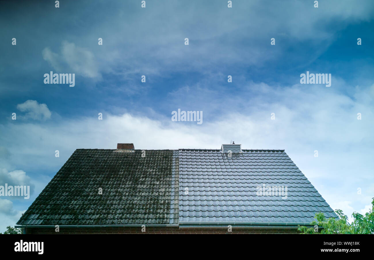 Un mezzo pulito sul tetto della casa mostra il prima e il dopo l effetto di un tetto di pulizia. Foto Stock