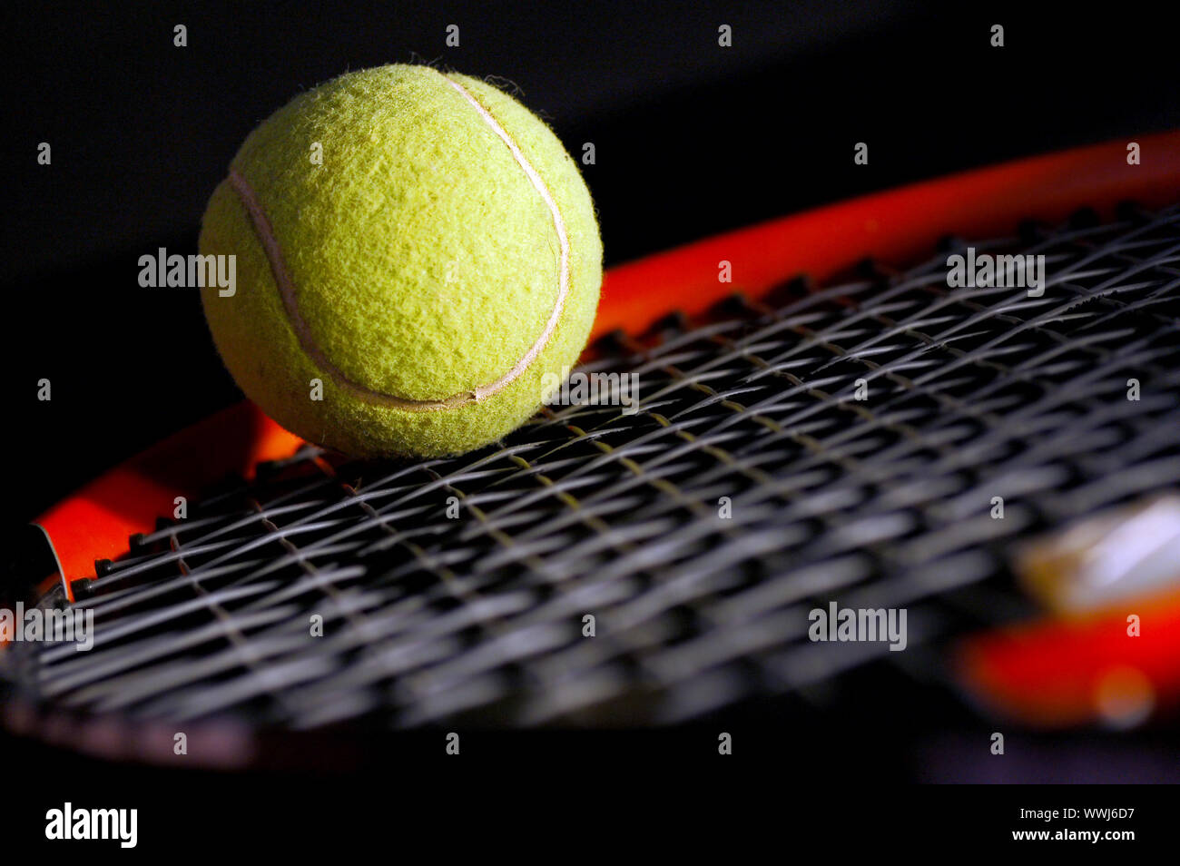 Attrezzatura da tennis - la palla e la racchetta su nero. Luce morbida e leggera profondità di campo a. Foto Stock