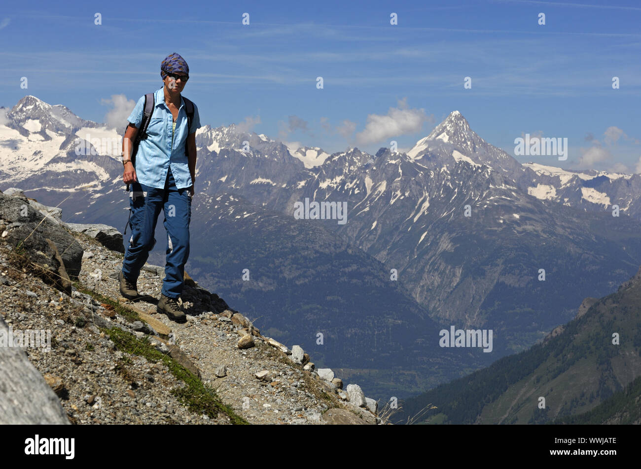 Escursionismo su uno stretto sentiero di montagna alta nelle Alpi del Vallese Foto Stock