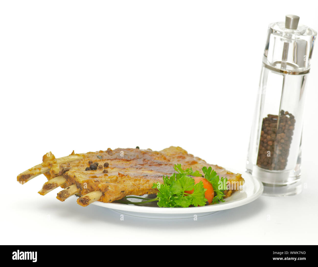 Grigliata di costolette di maiale sulla piastra bianca isolata su sfondo bianco Foto Stock