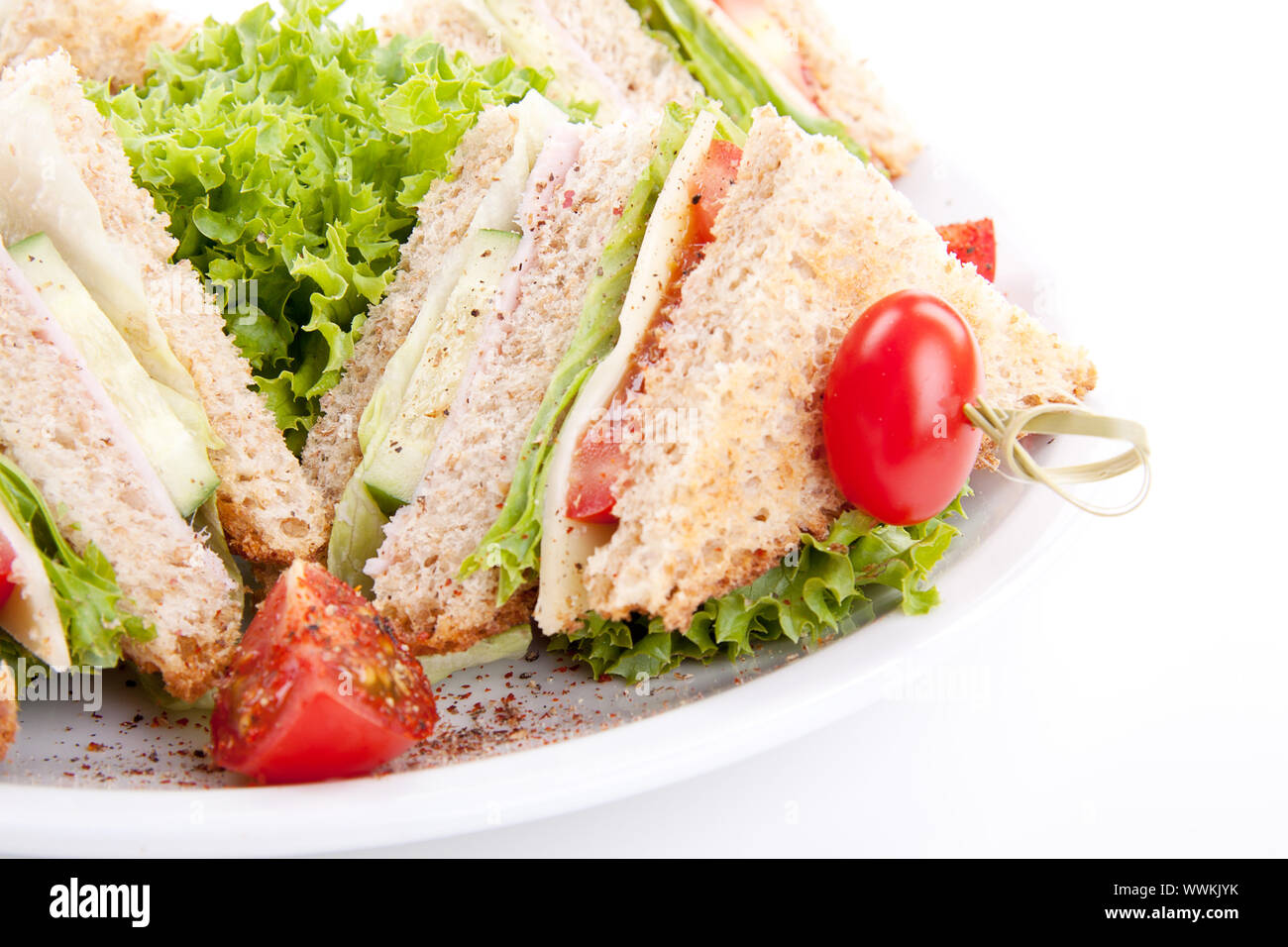 Nuovo club sandwich con prosciutto e formaggio, pancetta e insalata isolato Foto Stock