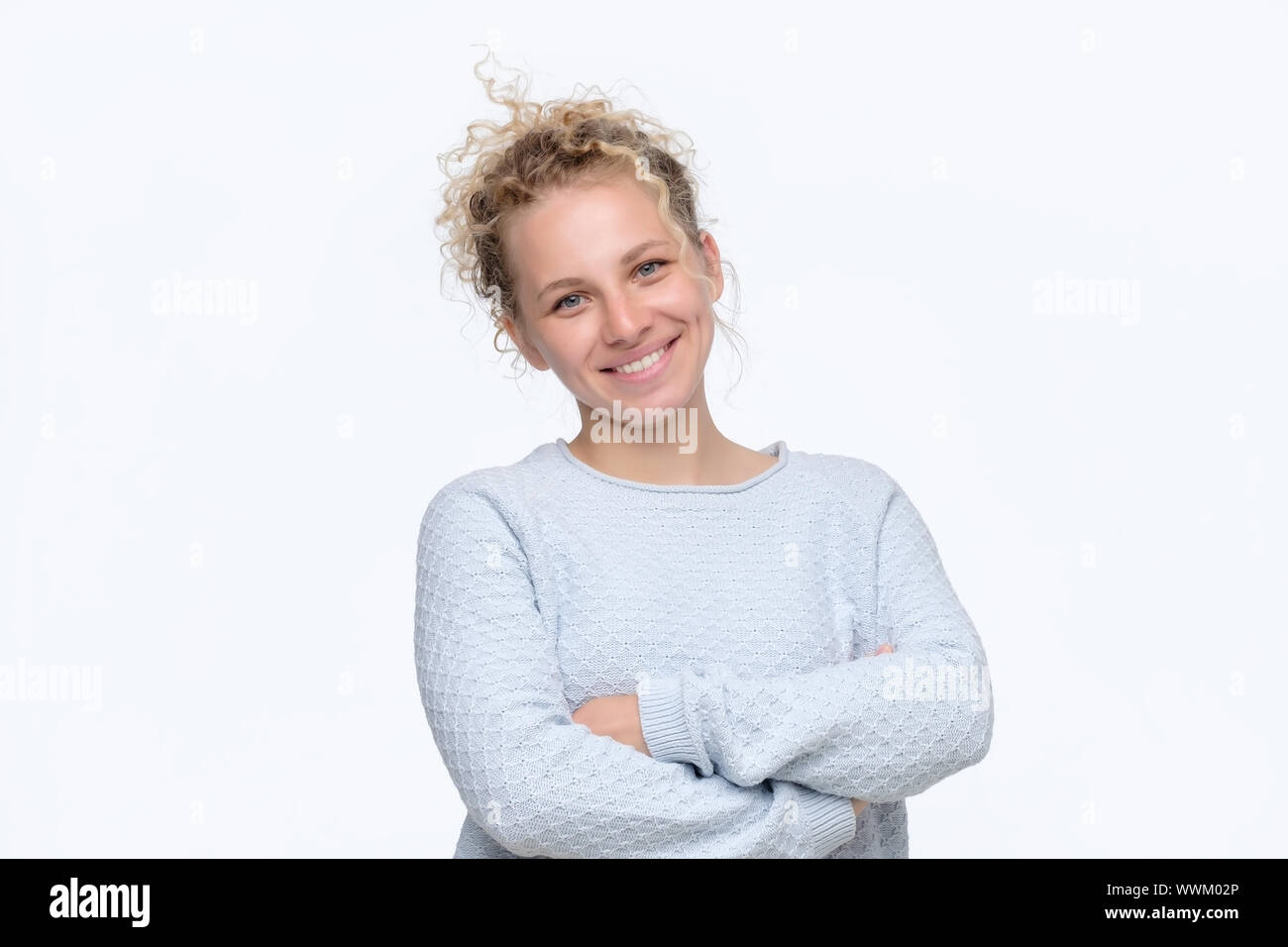 Sorridenti ritratto di donna con bracci incrociati essendo eccitato. Studio shot Foto Stock