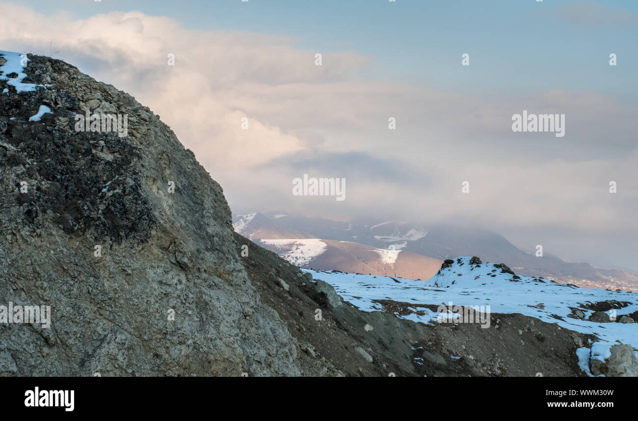 Montagna innevata e colline. In inverno il paesaggio di montagna. Foto Stock