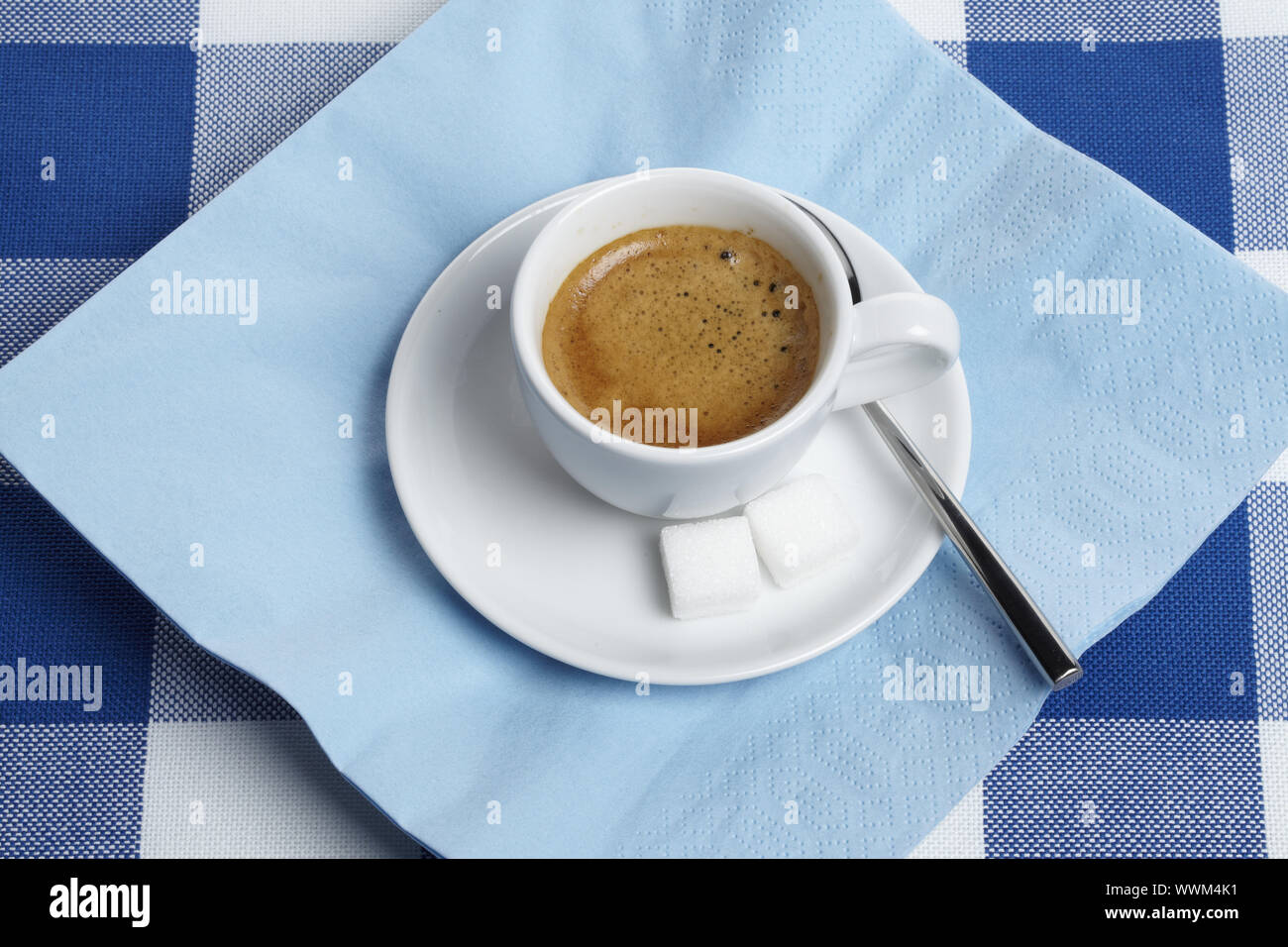 Espresso con cubetti di zucchero sulla tovaglia Foto Stock