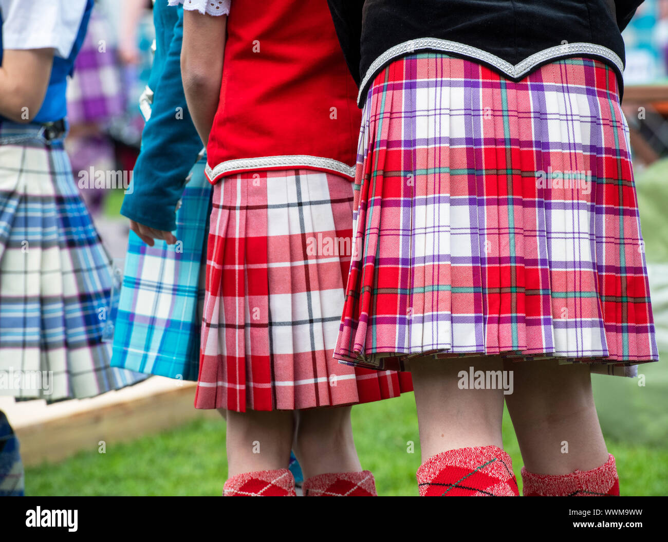 Altopiano giovani ragazze danza indossando variopinti tartan kilts a Peebles Highland Games. Peebles, Scottish Borders, Scozia Foto Stock