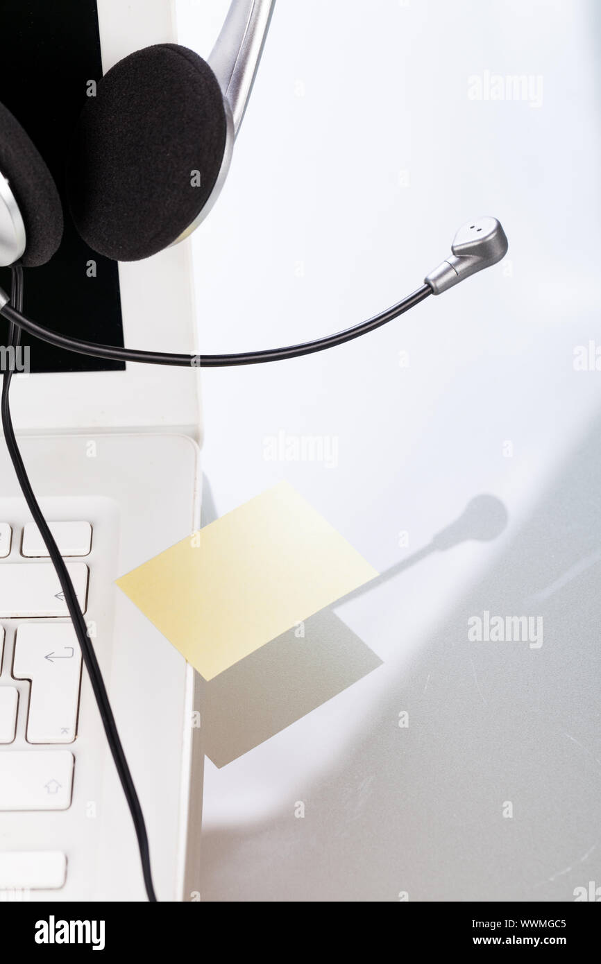 Tastiera auricolare notebook portatile in ufficio sulla scrivania Foto Stock
