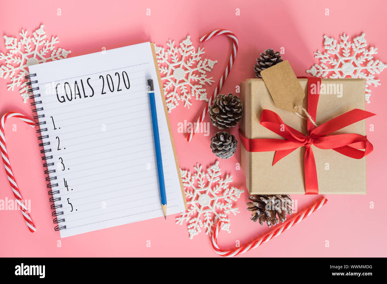 2020 Anno nuovo concetto. Obiettivi 2020 elenco nel Blocco Note confezione regalo e decorazione di Natale in rosa color pastello con spazio di copia Foto Stock