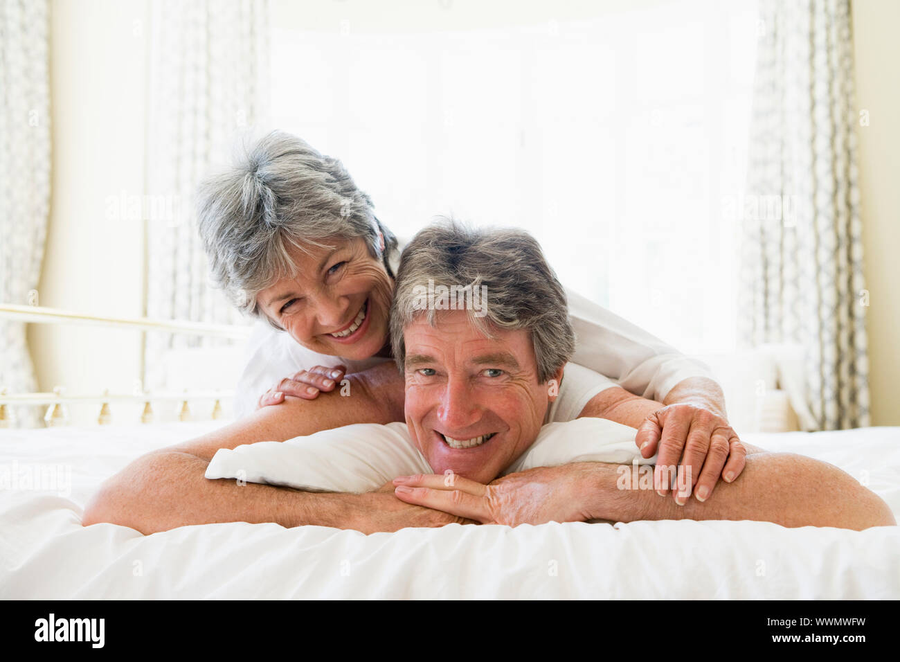 Giovane sdraiato sul letto insieme sorridente Foto Stock