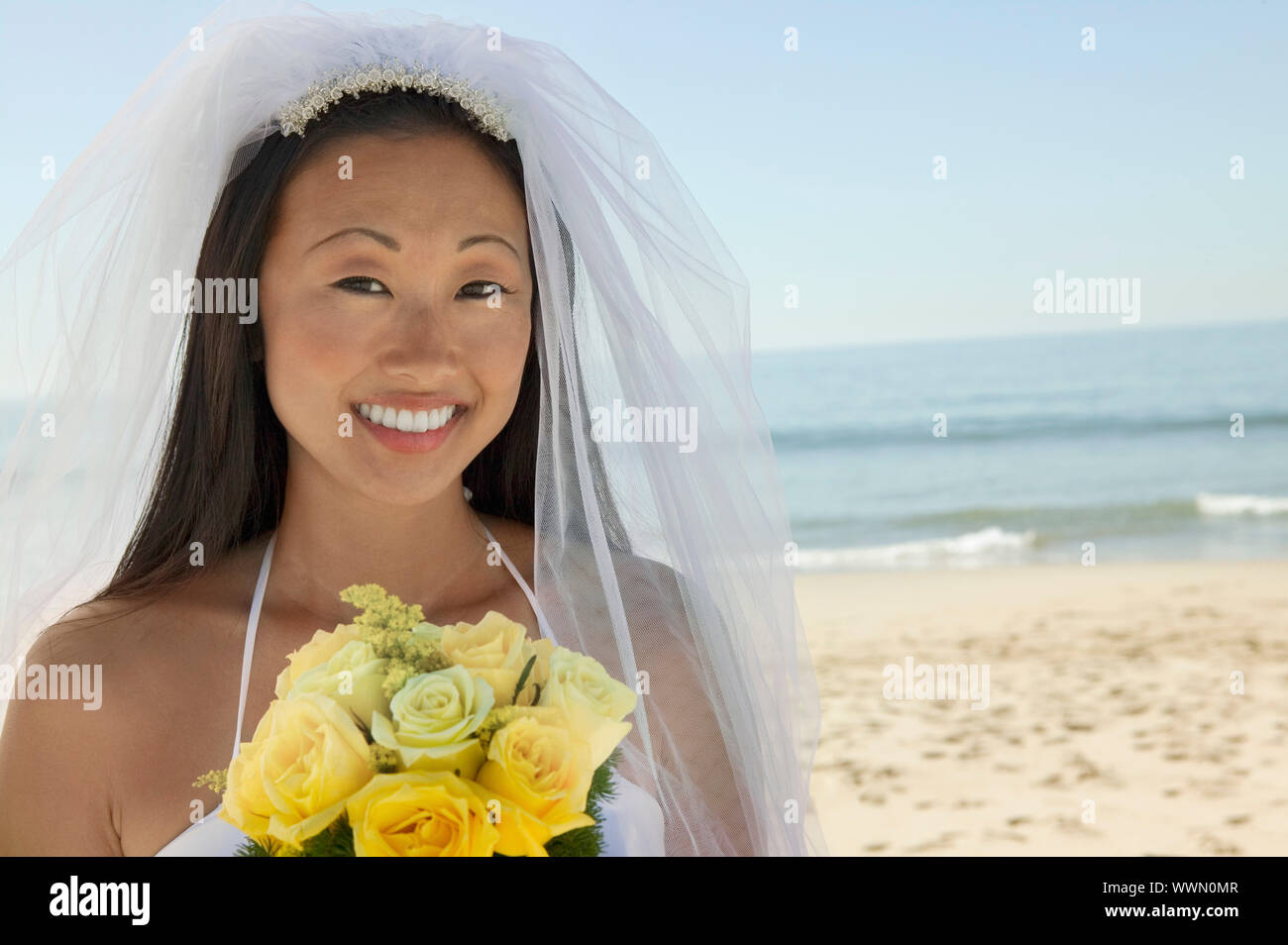 Sposa con bouquet sulla spiaggia Foto Stock