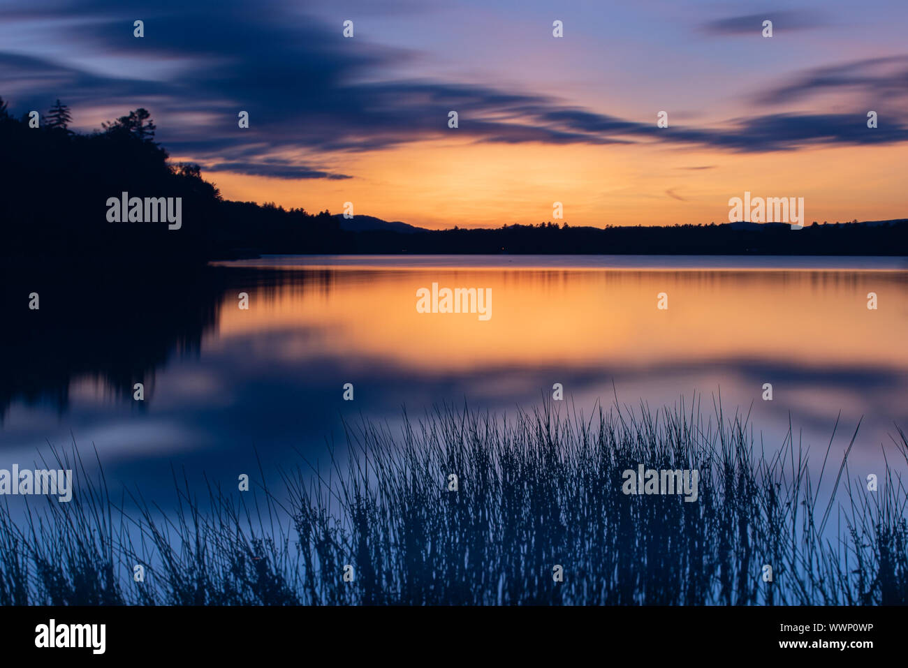 Una lunga esposizione immagine di un tramonto e di post-incandescenza sul Lago Pleasant nelle Montagne Adirondack, NY USA Foto Stock